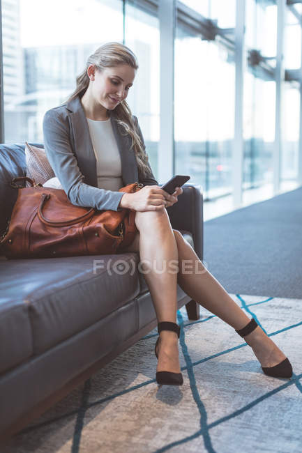 Nahaufnahme einer Geschäftsfrau mit dem Handy auf dem Sofa in der Lobby eines modernen Büros — Stockfoto