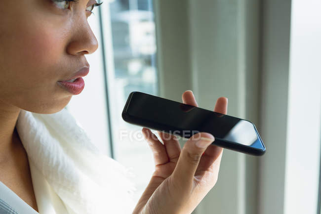 Close-up of businesswoman in hijab talking on mobile phone in corridor at modern office. — Stock Photo