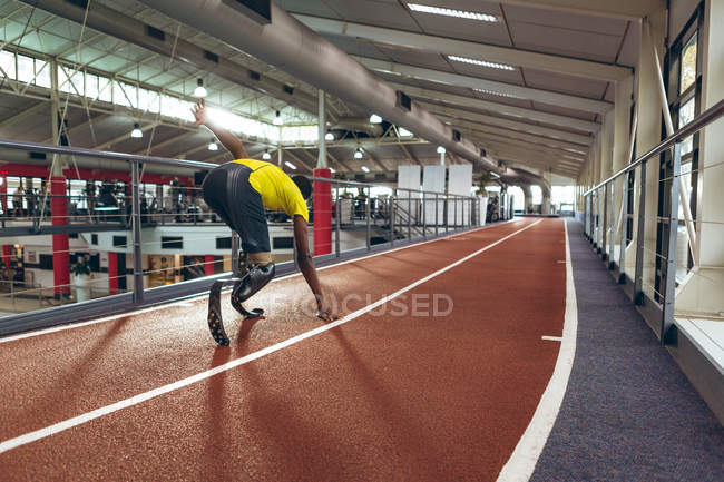 Vue arrière de l'athlétisme masculin afro-américain handicapé sur piste de course dans un centre de remise en forme — Photo de stock