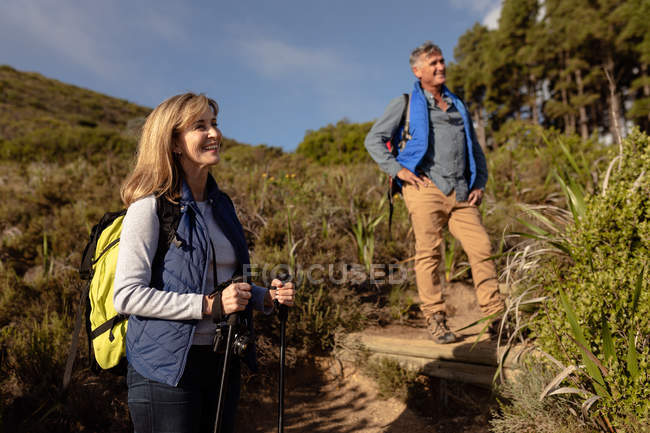 Vista lateral de perto de um homem e uma mulher caucasianos maduros que param para apreciar a paisagem durante uma caminhada — Fotografia de Stock