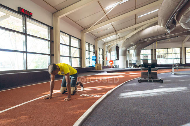 Vorderansicht eines behinderten afrikanisch-amerikanischen Mannes entspannt sich auf einer Laufbahn im Fitness-Center — Stockfoto