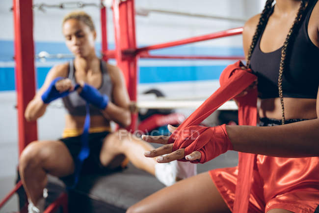 Des boxeuses afro-américaines habillées à la main au club de boxe. Forte combattante dans la boxe gymnase entraînement dur . — Photo de stock