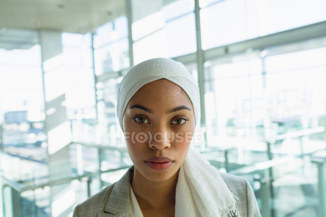 Close-up of businesswoman in hijab looking at camera in a modern office. — Stock Photo