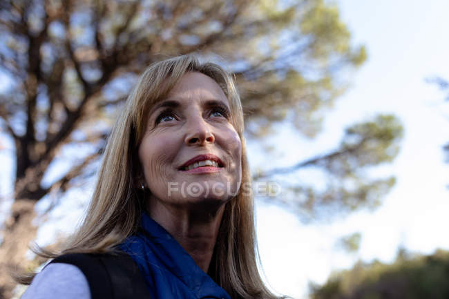 Front view close up of a mature Caucasian woman looking up at the scenery during a hike. — Stock Photo