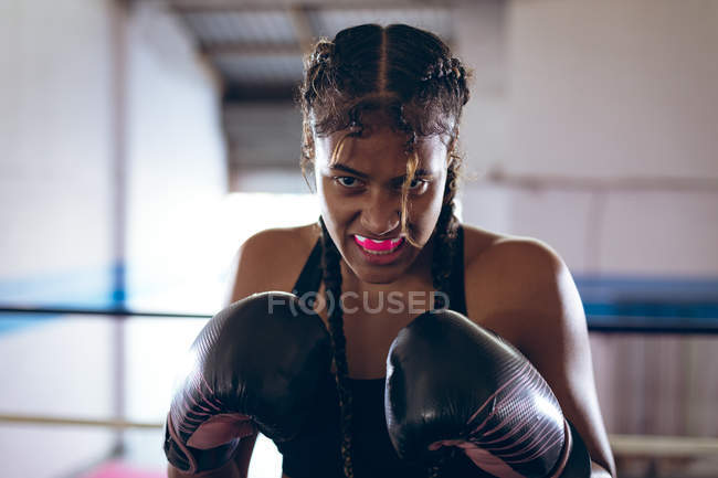 Close-up de boxeador feminino praticando boxe no clube de boxe. Forte lutador feminino no treinamento de ginásio de boxe duro . — Fotografia de Stock