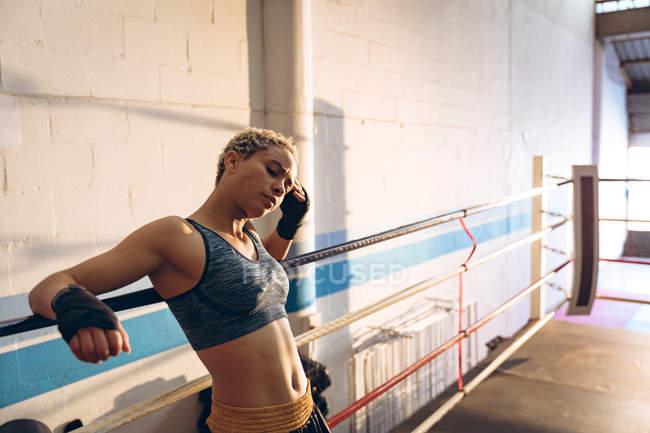 Stanca pugile che si riposa sul ring di pugilato al centro fitness. Forte combattente femminile in palestra di pugilato allenamento duro . — Foto stock