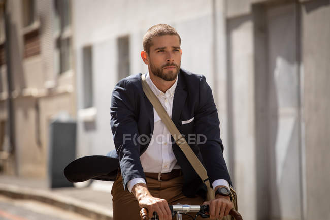 Вид спереди на молодого кавказца, едущего на велосипеде по городской улице. Цифровая реклама на ходу
. — стоковое фото
