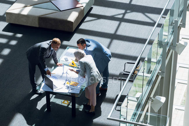 Високий кут зору архітекторів чоловічої та жіночої статі, які обговорюють план в офісі . — стокове фото