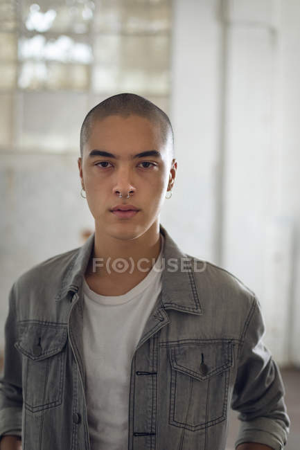 Front view of a young Hispanic-American man with piercing on both ears and nose — Stock Photo
