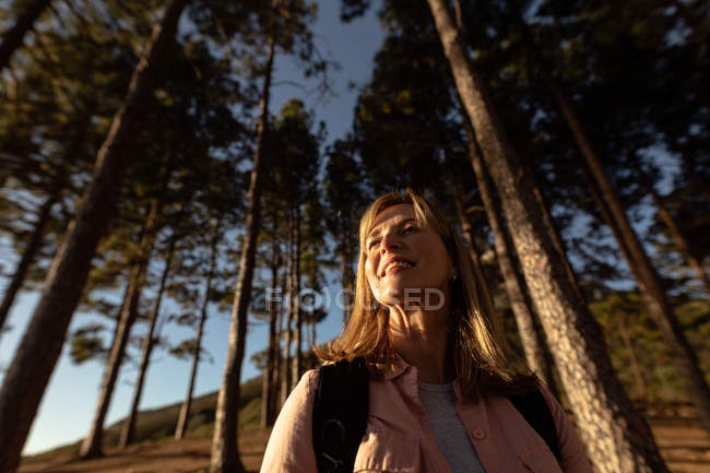 Nahaufnahme einer reifen kaukasischen Frau, die während einer Wanderung die Landschaft in einem Wald genießt. — Stockfoto