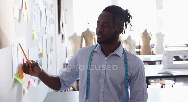 Vista frontal de um jovem estudante de moda afro-americano trabalhando em um estúdio na faculdade de moda — Fotografia de Stock