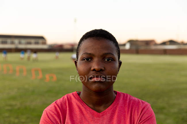 Portrait close up of a young adult African American female rugby player standing on a sports field looking to camera — Stock Photo