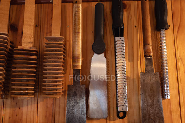Nahaufnahme traditioneller Geigenbauwerkzeuge auf einer Holzoberfläche in einer Werkstatt — Stockfoto