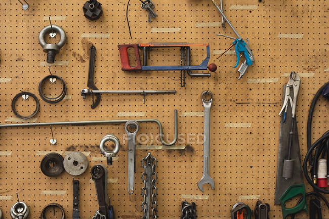 Front view close up of tools hanging on the wall in the machine shop at a processing plant — Stock Photo