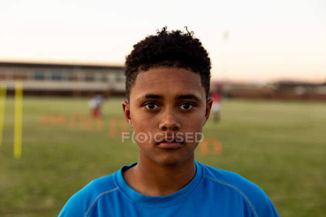 Portrait close up of a young adult mixed race female rugby player standing on a rugby pitch looking to camera — Stock Photo