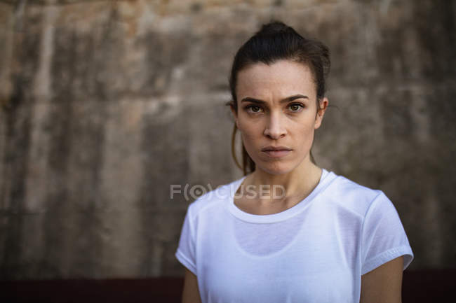 Portrait of a young Caucasian female tennis player, wall in a background — Stock Photo