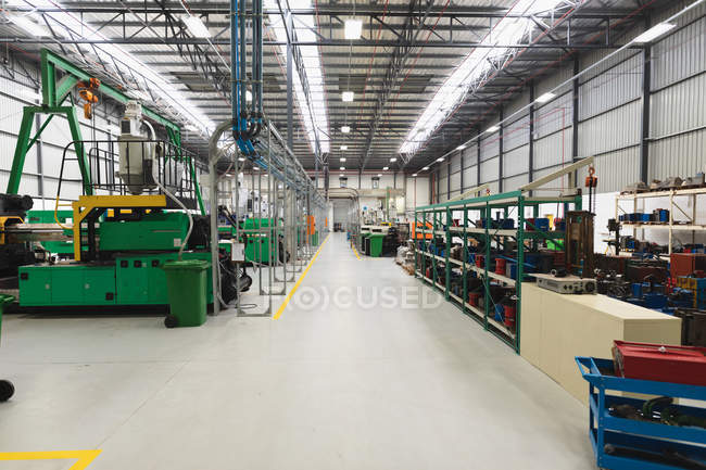 Vista frontal de uma fileira de equipamentos de processamento e uma área de armazenamento em um armazém em uma fábrica de processamento — Fotografia de Stock