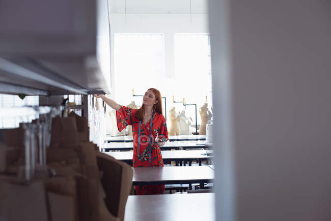 Vista frontal de uma jovem estudante de moda caucasiana trabalhando em um projeto em um estúdio na faculdade de moda — Fotografia de Stock
