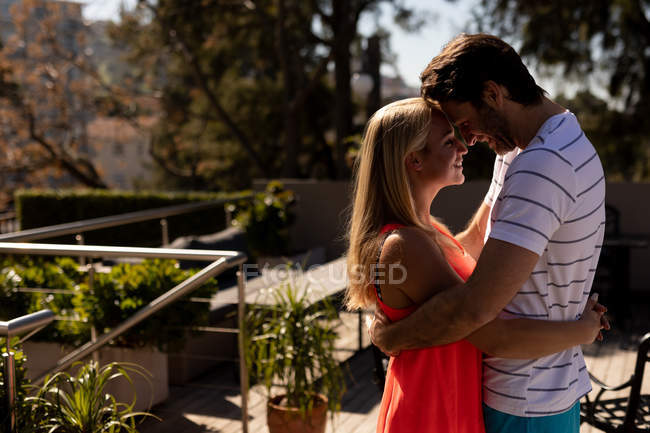 Vue latérale d'un jeune couple caucasien heureux se détendre ensemble en vacances, embrasser dans un jardin — Photo de stock