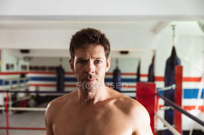 Portrait close up of a young Caucasian male boxer in a boxing ring looking to camera — Stock Photo