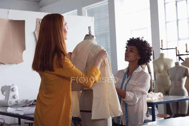 Vista frontal de uma jovem negra caucasiana mista estudante de moda feminina trabalhando em um projeto em um estúdio na faculdade de moda — Fotografia de Stock