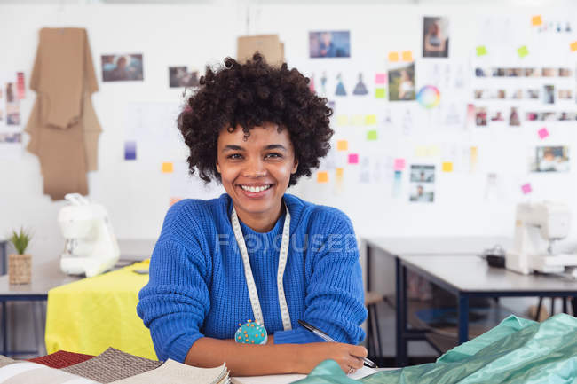 Porträt einer jungen Modestudentin mit gemischter Rasse, die in einem Atelier der Modehochschule an einem Design arbeitet — Stockfoto