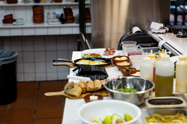Side view of ingredients and a frying pan waiting for a chef in a restaurant kitchen — Stock Photo
