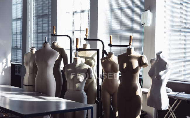 Front view of a group of mannequins standing in front of a window in a studio at a fashion college — Stock Photo
