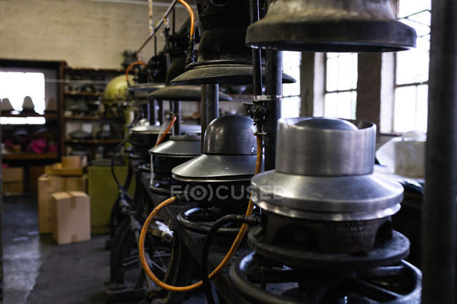 Vista laterale di una fila di vecchie macchine utilizzate nel processo di fabbricazione di cappelli in officina in una fabbrica di cappelli — Foto stock