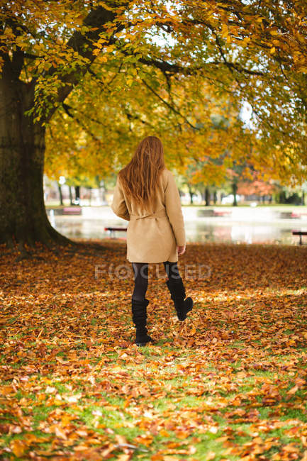 Vista posteriore della donna che cammina nel parco. — Foto stock