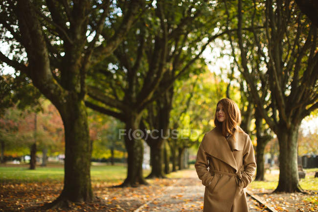 Woman with hands in her pocket walking in the park. — Stock Photo