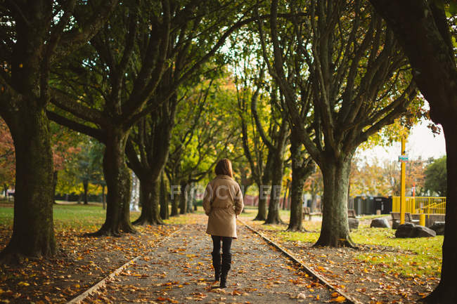 Rückansicht einer Frau, die im Park spaziert. — Stockfoto