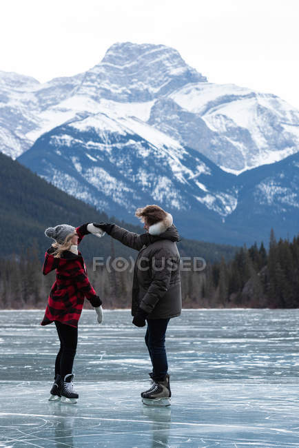 Vista lateral do jovem casal caucasiano dançando em pé na paisagem nevada natural — Fotografia de Stock