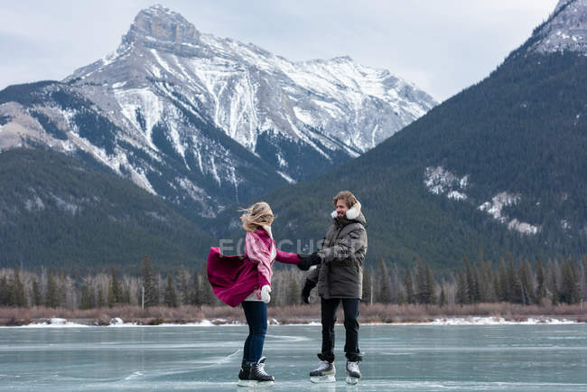 Вид збоку щасливий кавказька пара танці стоячи в природних снігових ландшафтів — стокове фото