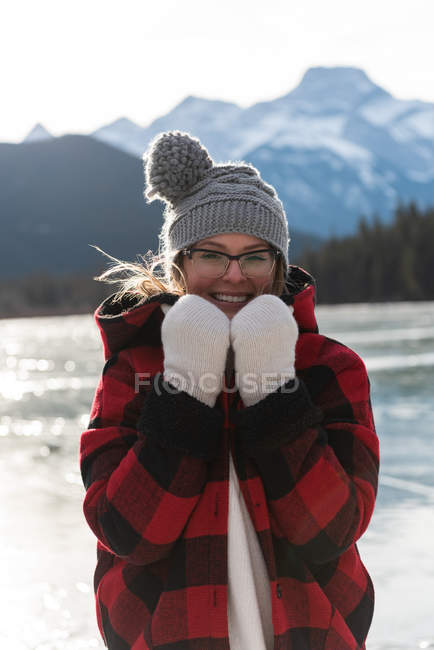 Portrait de heureuse jeune femme caucasienne debout dans un paysage enneigé naturel avec tenue d'hiver . — Photo de stock