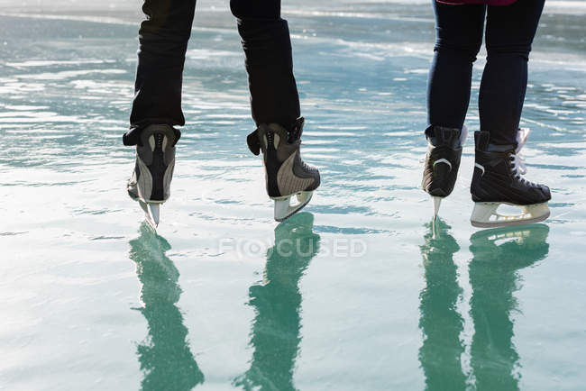 Meio comprimento de casal juntos patinando na paisagem nevada natural — Fotografia de Stock