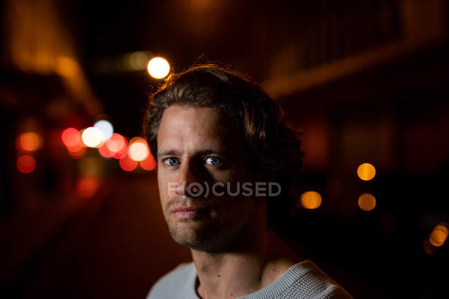Portrait of a young Caucasian man in the street looking to camera in the evening — Stock Photo