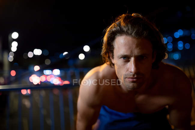 Portrait of a young Caucasian man in the street during his late evening workout — Stock Photo