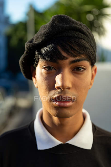 Porträt eines modischen jungen Transgender auf der Straße, der eine Baskenmütze trägt — Stockfoto