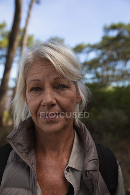 Retrato de uma mulher madura caucasiana sorrindo para a câmera durante uma caminhada no campo — Fotografia de Stock