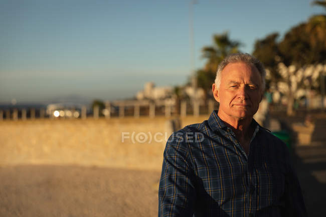 Portrait d'un homme blanc mature au bord de la mer au coucher du soleil — Photo de stock
