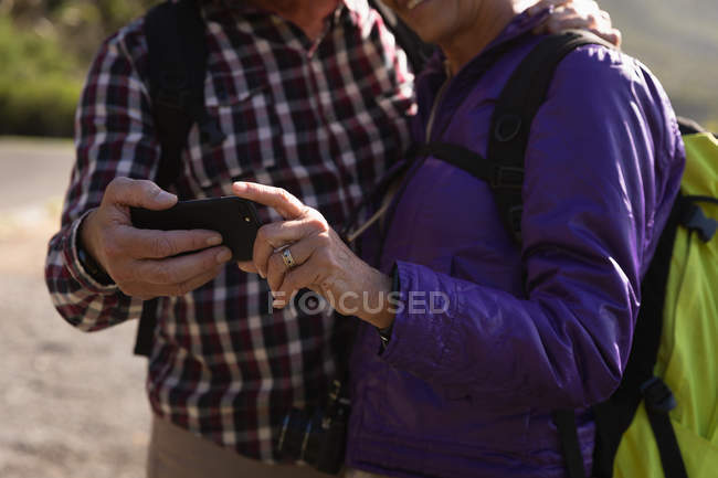 Vista frontal seção média de um homem e mulher caucasiano maduro tomando uma selfie em um ambiente rural — Fotografia de Stock