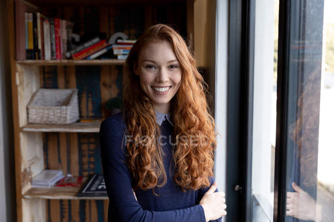 Портрет молодої кавказької жінки, що стоїть у творчому кабінеті зі схрещеними руками, посміхаючись до камери.. — стокове фото
