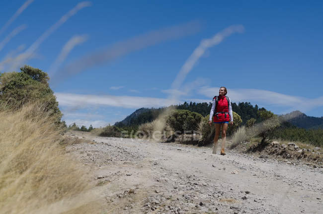 Frau mit Rucksack läuft auf Feld gegen Himmel — Stockfoto