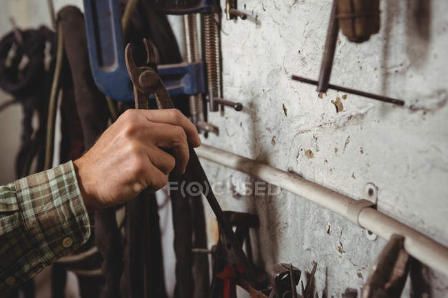 Hand of craftsman removing tool in workshop — Stock Photo