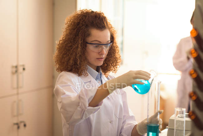 Adolescente femmina pratica esperimento di chimica in laboratorio — Foto stock