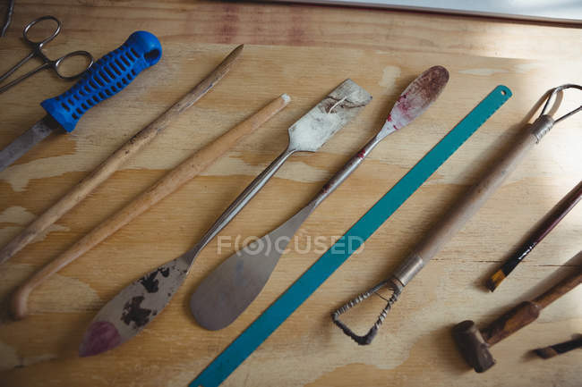 Various metal tools on wooden table in workshop — Stock Photo