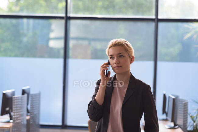 University student talking on mobile phone in computer class at college — Stock Photo