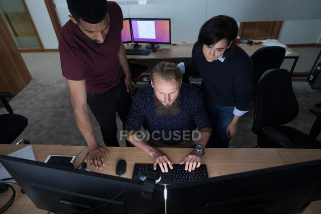 Колеги, які працюють разом за столом в офісі — стокове фото