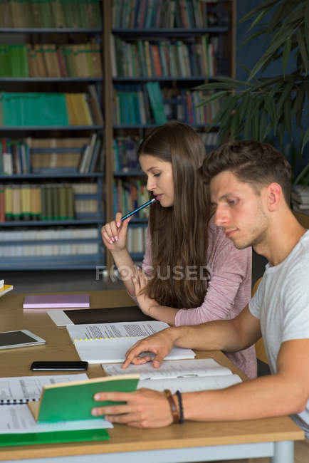 Visão de alto ângulo de estudantes universitários estudando na mesa em sala de aula — Fotografia de Stock
